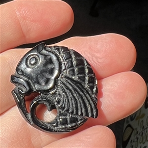 Pierced casein button of a realistic fish. 