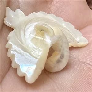 Carved pearl button of a realistic flying crane.