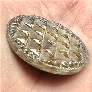 Lacy glass button of a pattern of triangles. 