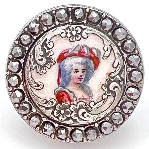 Enamel on white metal button of a woman in hat with border of faceted cut-steels.