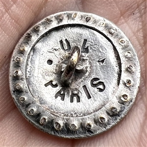 Enamel on white metal button of a woman in hat with border of faceted cut-steels.