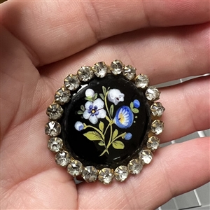 Enamel button of flowers with paste border.