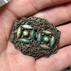Applied filigree over metal with turquoise button. 