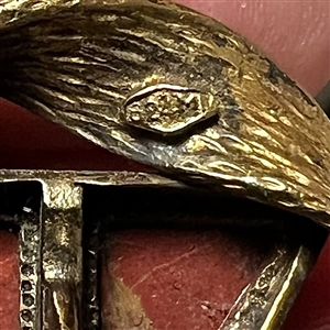 Couture button of triangular red Jasper with a “möbius strip border of brass.