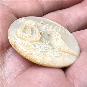 Pearl button of music - a harp, musical staff with notes and a singing bird.