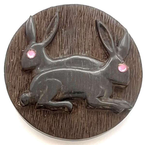 Leo Crabtree studio button of two rabbits with pink eyes.