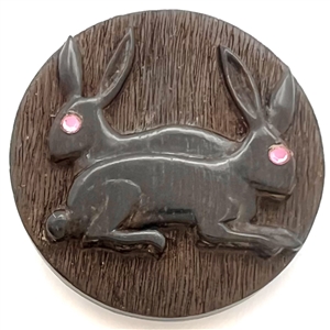 Leo Crabtree studio button of two rabbits with pink eyes.