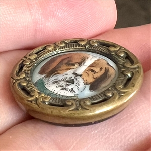Porcelain in metal button of a dog's face.