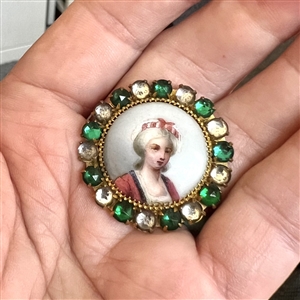 A 19th c. Painted porcelain button of a woman set in metal with boarder of pastes.
