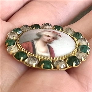 A 19th c. Painted porcelain button of a woman set in metal with boarder of pastes.