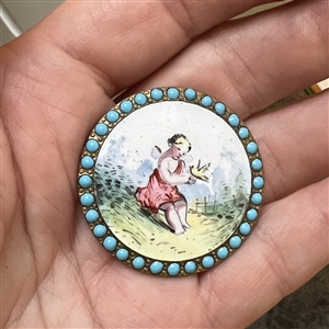 “Cherub with a Bird painted enamel button with encrusted blue enamel border.