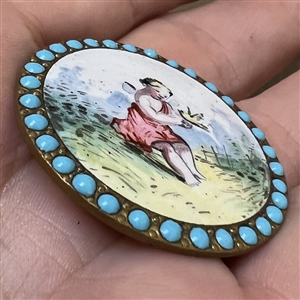“Cherub with a Bird painted enamel button with encrusted blue enamel border.