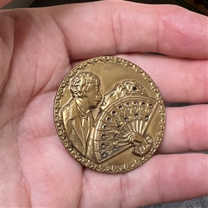 Stamped brass button of “The Stolen Kiss.