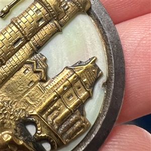 Brass escutcheon over pearl button of  “Le Tour de Nesle.