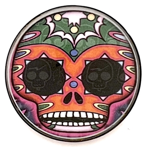 Paper under glass set in metal button of “day of the dead" skull.
