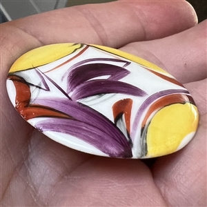 Painted porcelain button of an abstraction of a window with plant life.
