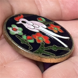 Modern cloisonné button of a bird among flowers. 