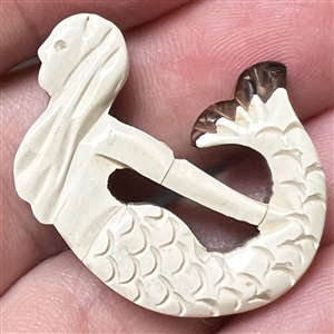 Vintage carved casein laminated over wood button of a mermaid.