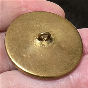 Painting on natural material button of a woman in feathered hat.