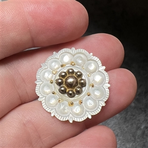 A medium size 18th c. Carved pearl button with gilded metal center.