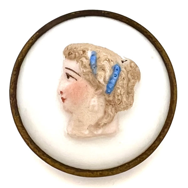 Painted glass button of a womans head set in metal.