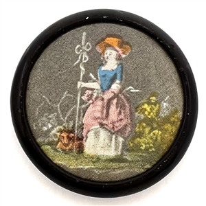 Printed paper under plastic button of “Little Bo Peep."
