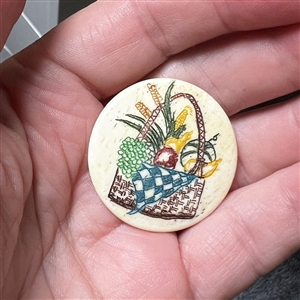 Incised and inked natural material button a full picnic basket.