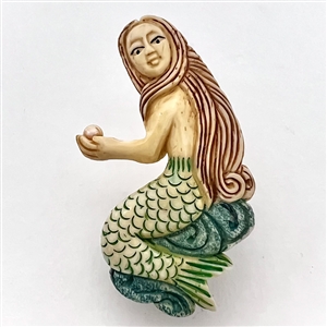 Carved natural material button of a realistic mermaid.