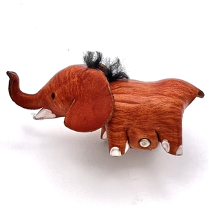 Tooled and dyed leather button of an elephant.