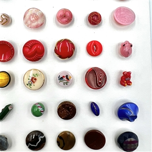 Two cards of 151 clear and colored glass buttons. 