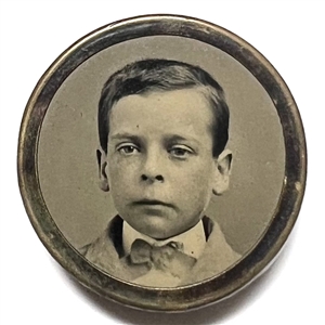 Tintype button of a boy in a bow tie set in metal.