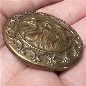 Brass button of a closed mouth rooster.