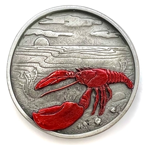 Battersea pewter show button of a lobster on the shore.
