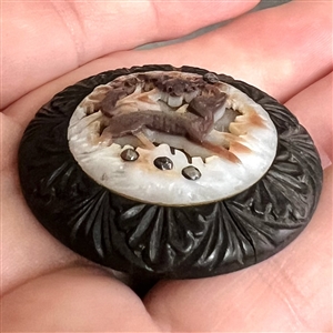EXQUISITE cameo carved pearl with open work of dog in foliage riveted to wood button with cut-steels.