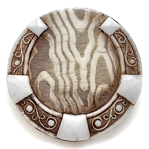 Large Div I white glass button of horseshoe over imitation fabric.