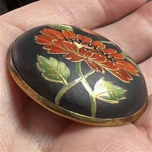 Painted and gold encrusted flowers on glass set in metal button.