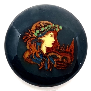 Foil and transfer on casein button of a woman and city scene.